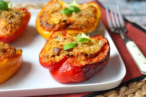 Peperoni ripieni al forno, un classico delle ricette con peperoni, guarniti con basilico fresco.