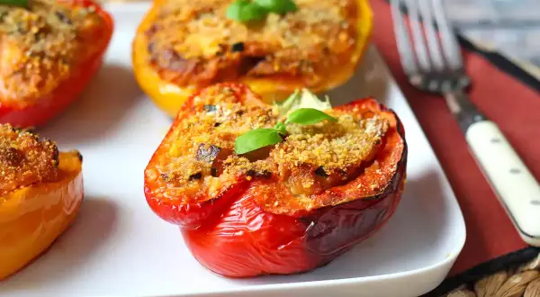 Peperoni ripieni al forno, un classico delle ricette con peperoni, guarniti con basilico fresco.