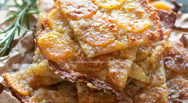 Schiacciata di patate croccante, dorata e invitante, con fette sottili di patate e un tocco di rosmarino.