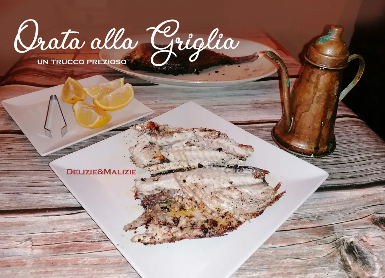 Orata alla griglia succulenta, servita con spicchi di limone e un'antica oliera in rame. Un vero tesoro culinario.