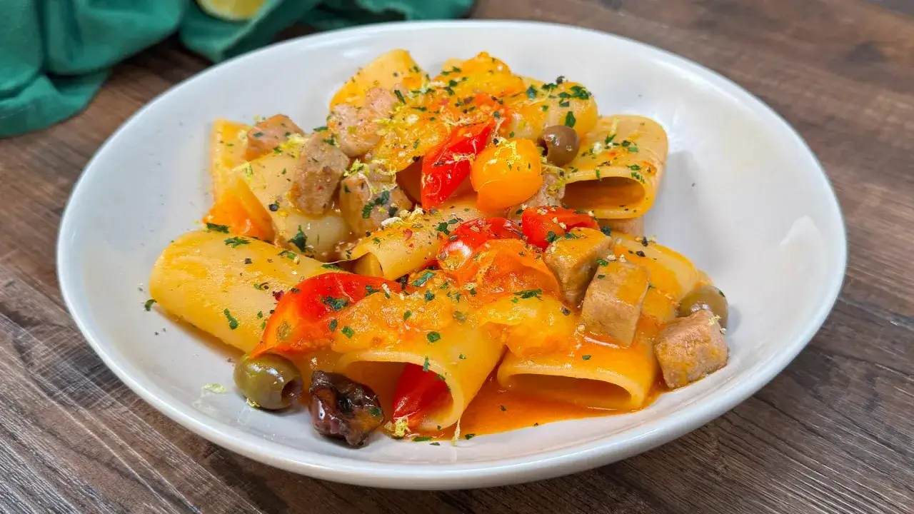 Paccheri con tonno fresco, pomodorini, olive e scorza di limone. Un piatto colorato e saporito, perfetto per un pranzo estivo.
