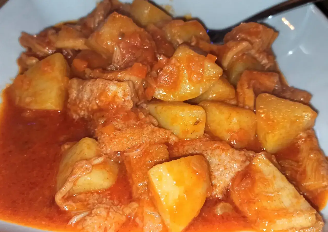 Un piatto invitante di trippa con patate, cotta in un sugo rosso saporito.