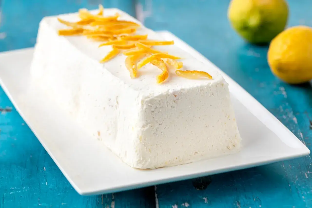Semifreddo al limone, un dolce fresco e cremoso, guarnito con scorzette candite.