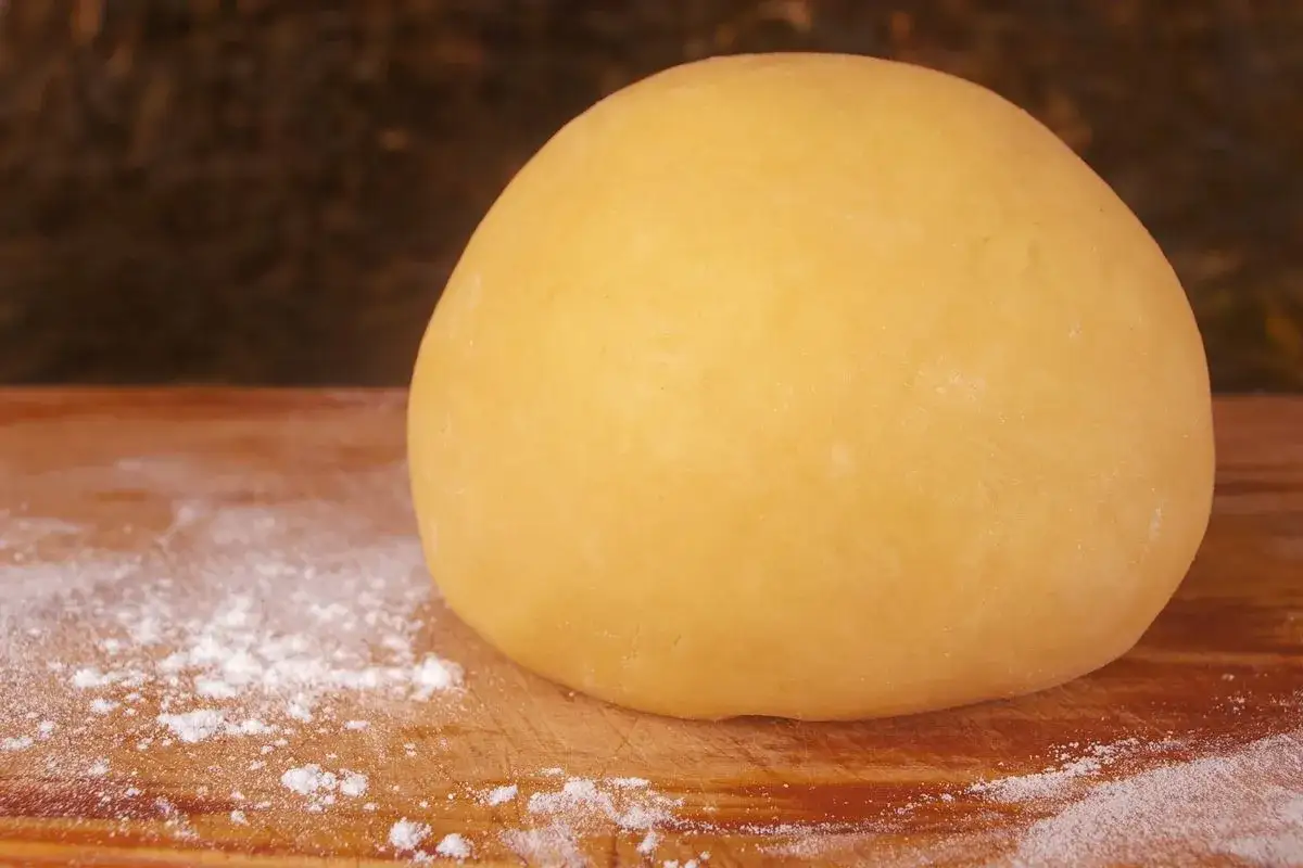 Impasto giallo dorato, pronto per diventare la base di una deliziosa pastiera. Pasta frolla per pastiera 1 kg.