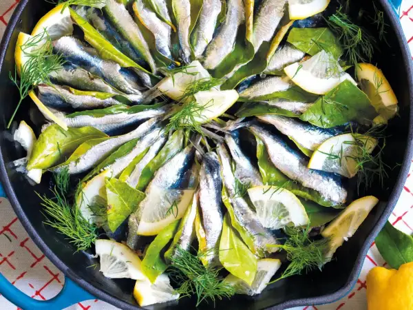 Sardine in padella con limone, alloro e finocchietto fresco, pronte per essere gustate.